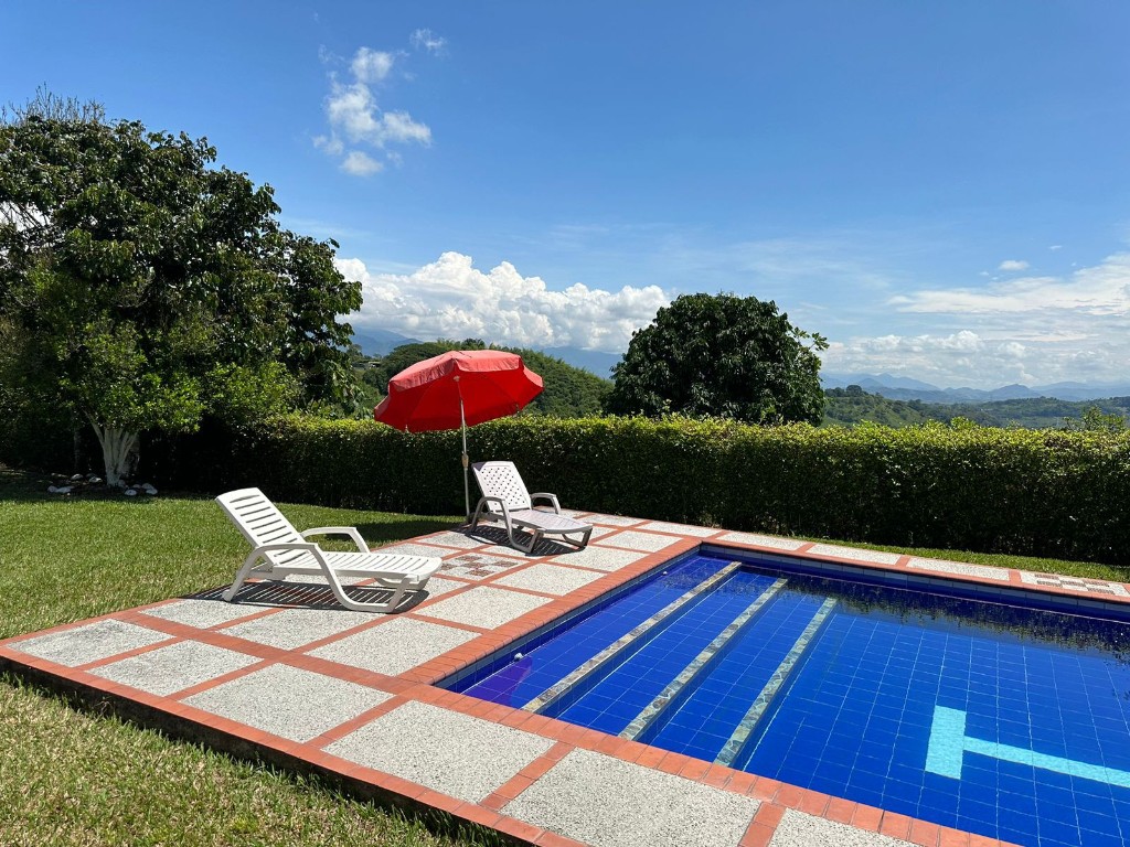 Piscina con zona de asoleo y vista a las montañas
